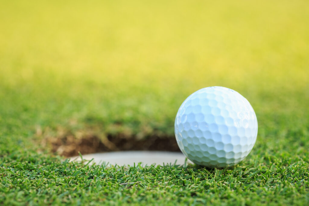 Golf ball on lip of cup in course